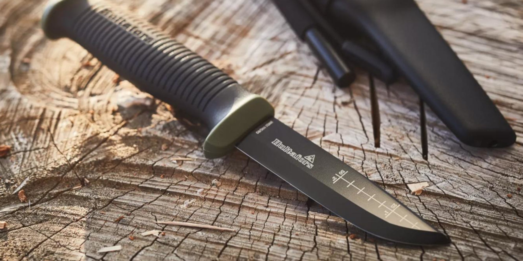 Black knife with a visible brand logo on a wooden surface